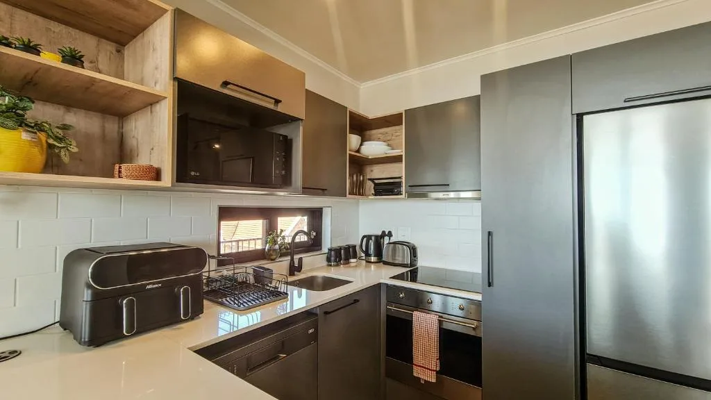 Modern kitchen with stainless steel appliances, white cabinetry, and countertop