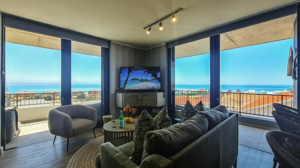 Modern lounge with ocean views through floor-to-ceiling windows and contemporary furnishings