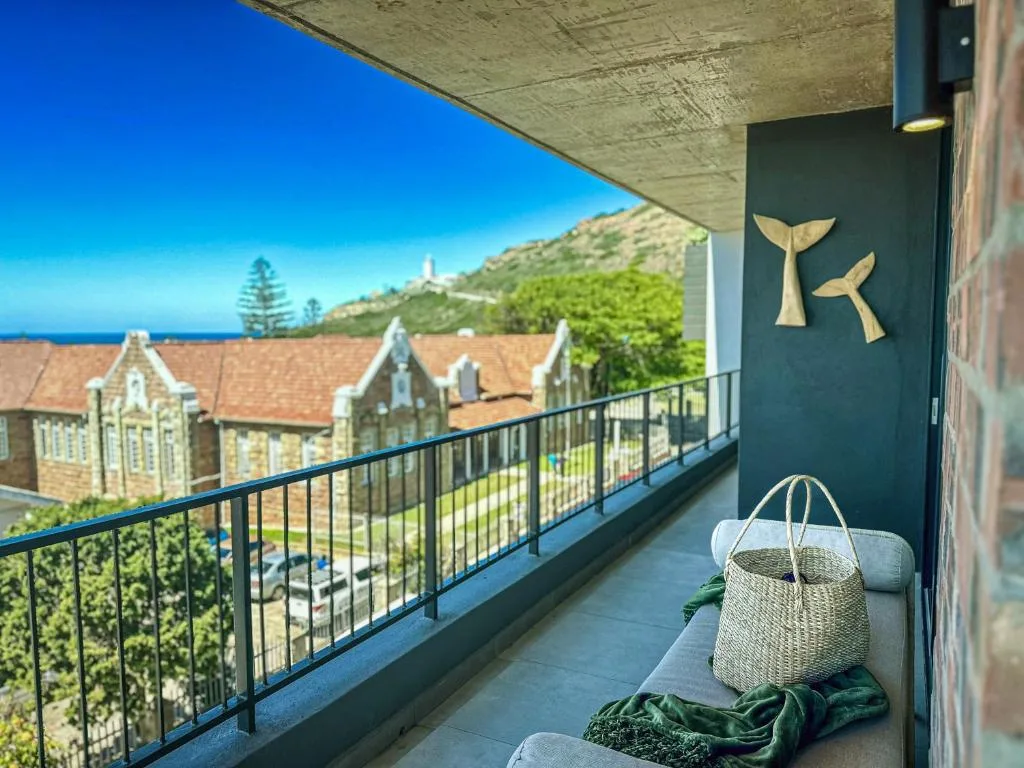 Seaside balcony overlooking historic buildings, mountains, and ocean horizon