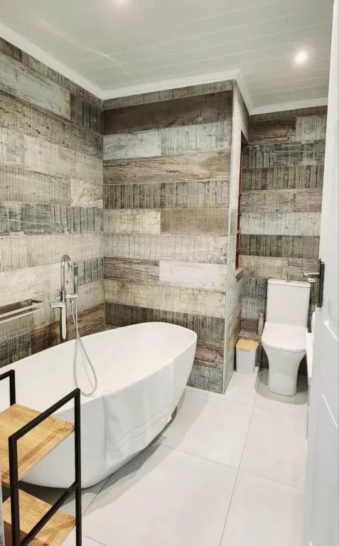 Modern bathroom with freestanding white bathtub and walk-in shower enclosure