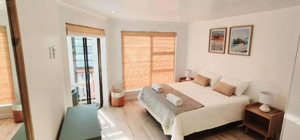 Spacious bedroom with king bed, wooden nightstands, and garden views