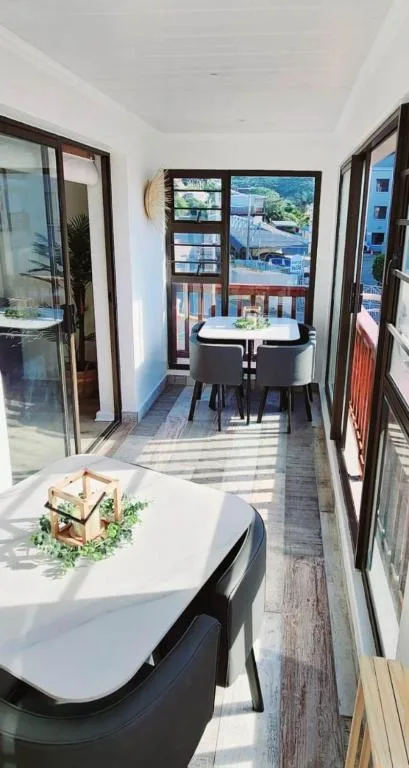 Sunny outdoor deck with dining table and scenic coastal views