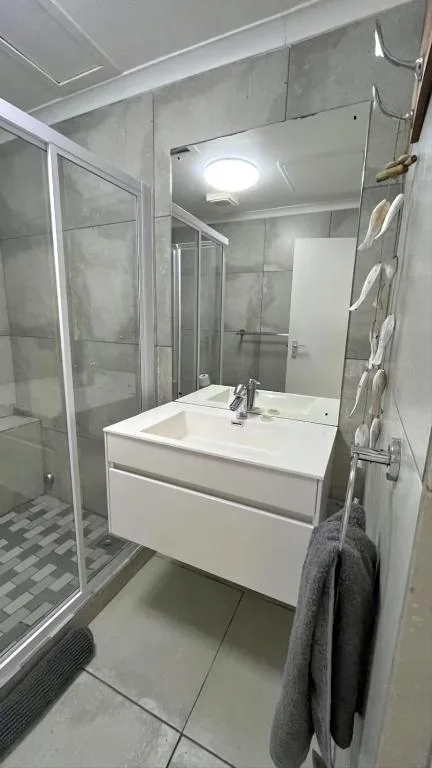 Modern bathroom with white vanity sink and glass shower enclosure