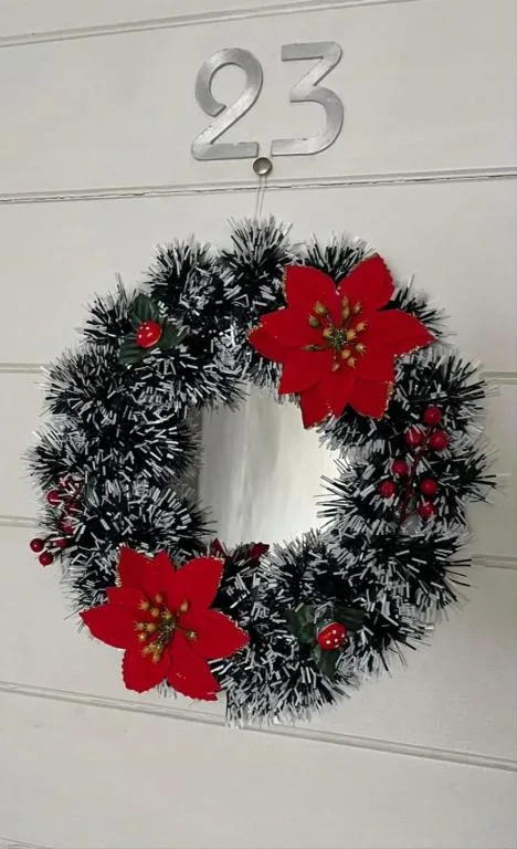 Festive black and red wreath with poinsettia flowers on garage door