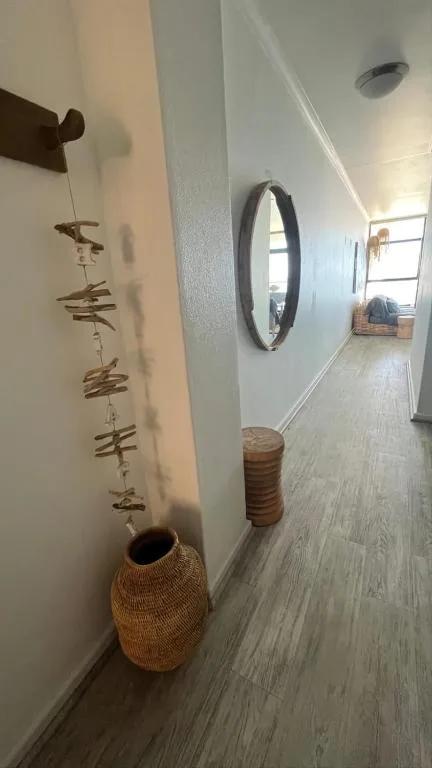 Hallway with woven basket, mirror, and decorative wall hanging