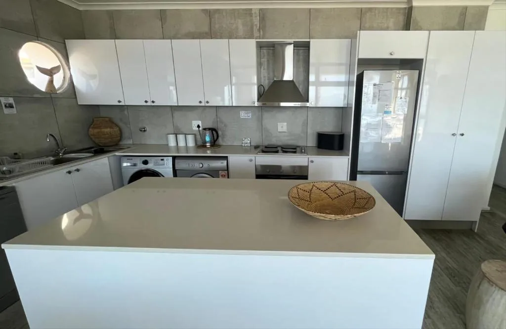 Modern kitchen with white cabinetry, island counter, and stainless steel appliances