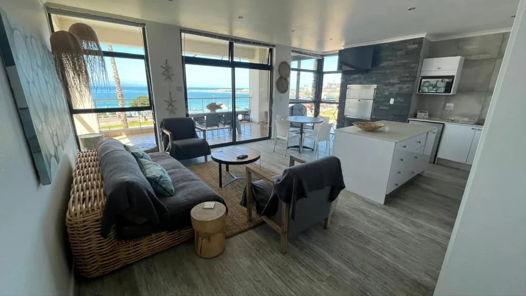 Modern lounge with sofa, ocean view through glass doors and windows