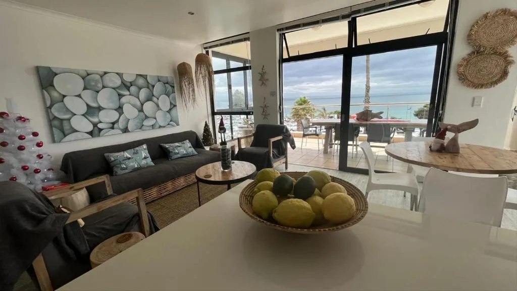 Modern lounge with sofa, ocean view through floor-to-ceiling windows