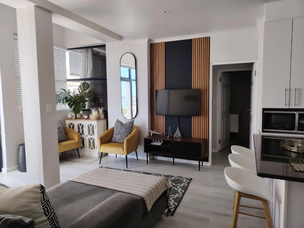Modern living room with mustard armchairs, wall-mounted TV, and contemporary decor