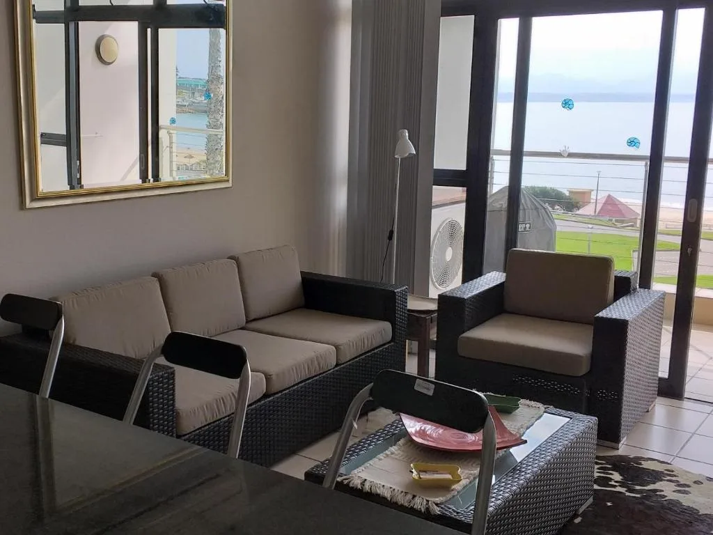 Modern lounge with gray upholstered seating and lagoon views through glass doors