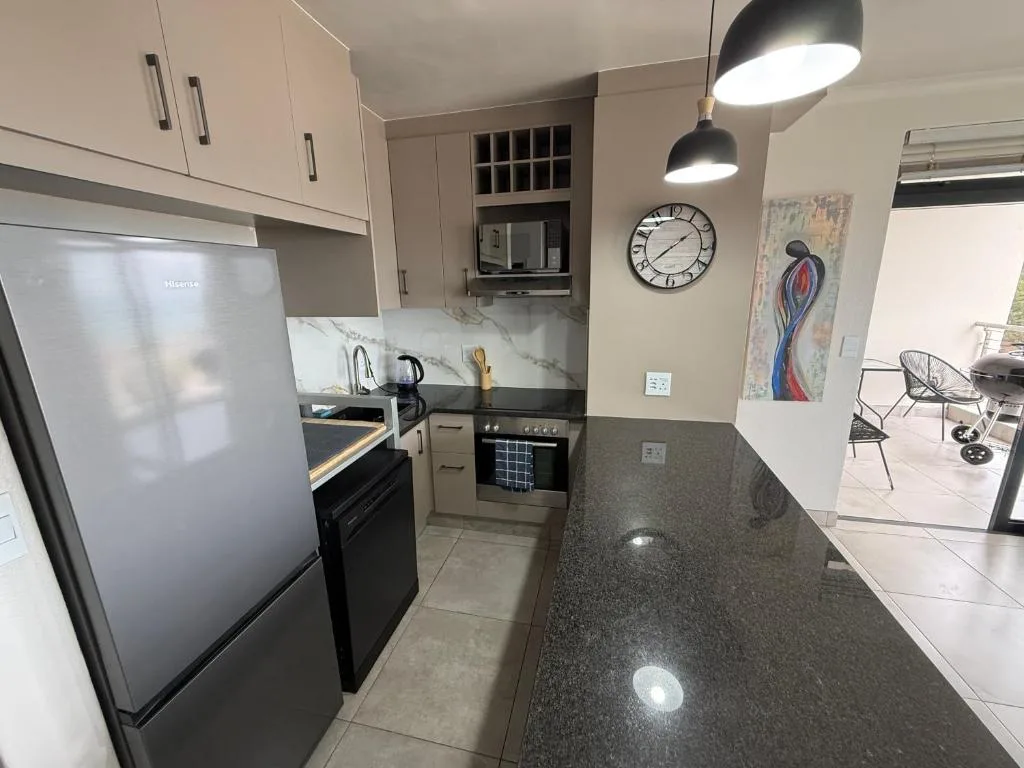 Modern kitchen with stainless steel appliances and dark granite countertops