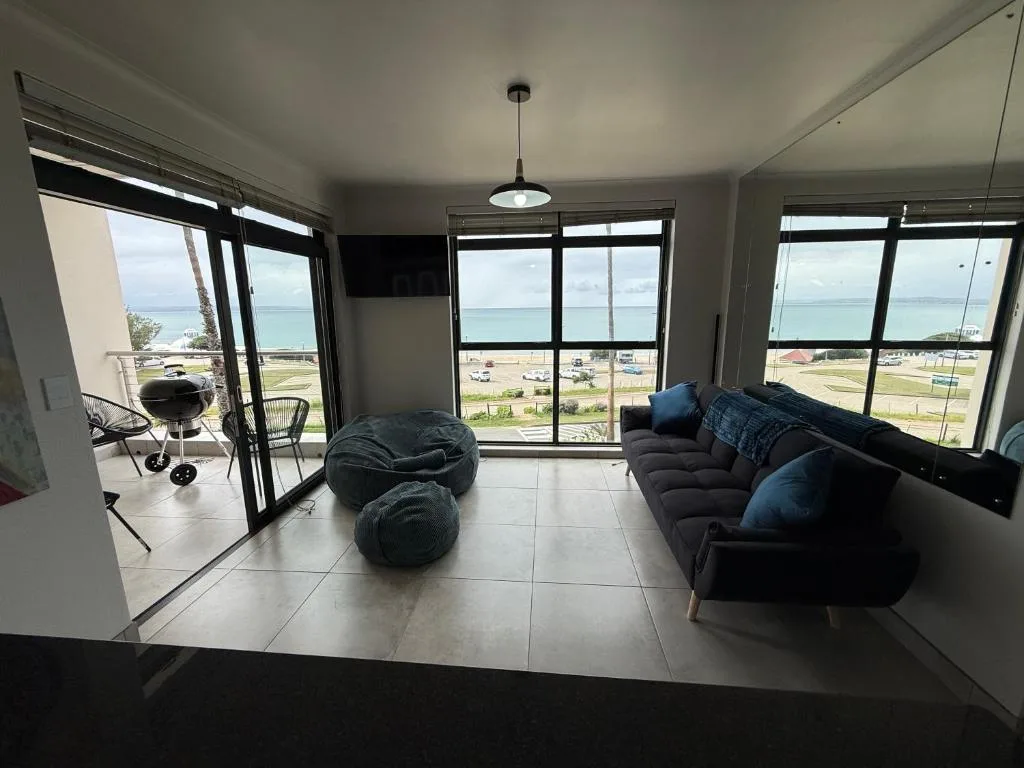 Modern lounge with black sofa, bean bags, ocean views through large windows