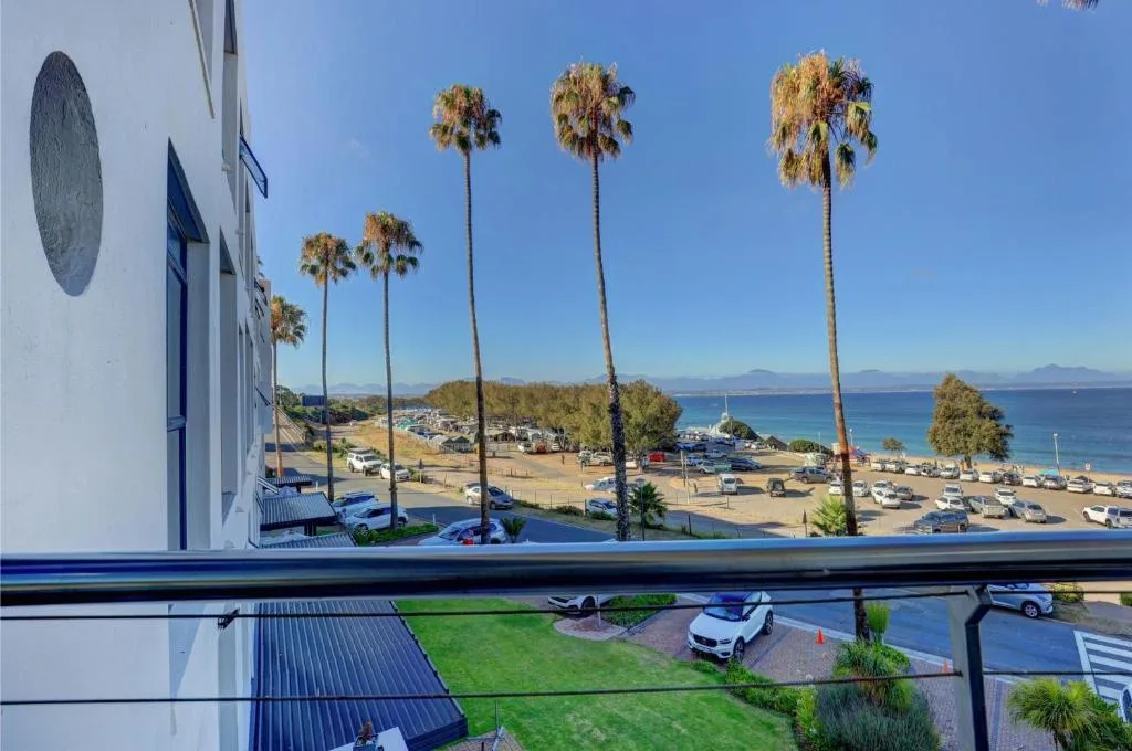 Stunning coastal sea view with beach, palm trees, and mountains beyond