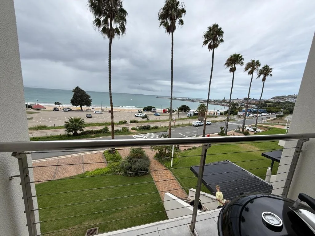 Scenic coastal view from balcony overlooking beach and palm trees