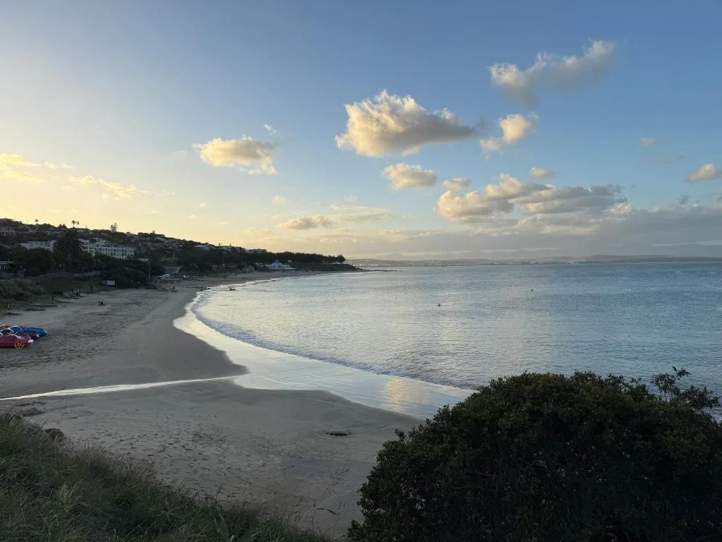 Scenic beach cove with turquoise waters and coastal homes on hillside