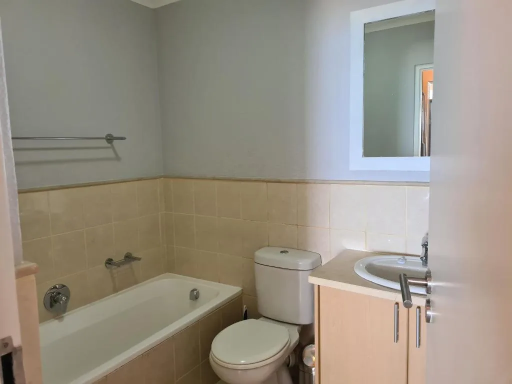 Clean bathroom with bathtub, toilet, vanity sink, and large mirror