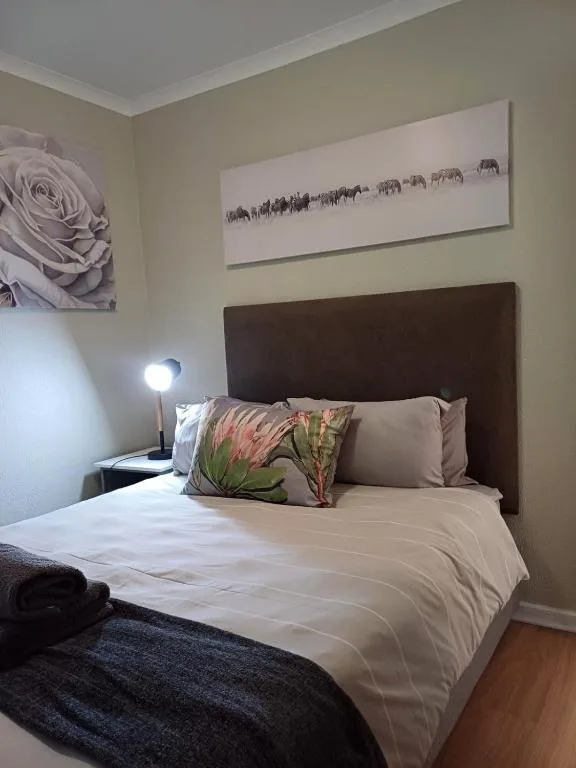 Bedroom with dark headboard, white bedding, and decorative pillows