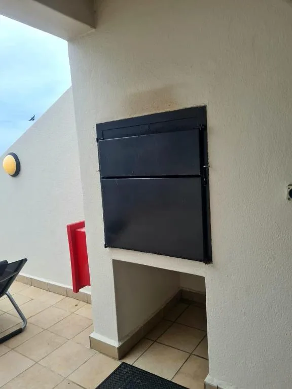 Outdoor patio area with black storage box and tiled flooring