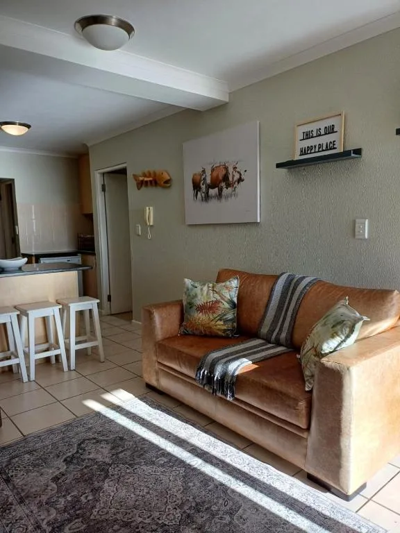 Open-plan lounge with cognac leather sofa and wildlife wall art