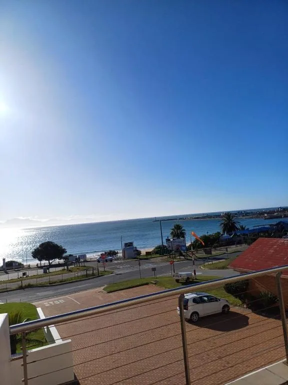 Coastal view of Mossel Bay with ocean, beach, and town across sparkling water