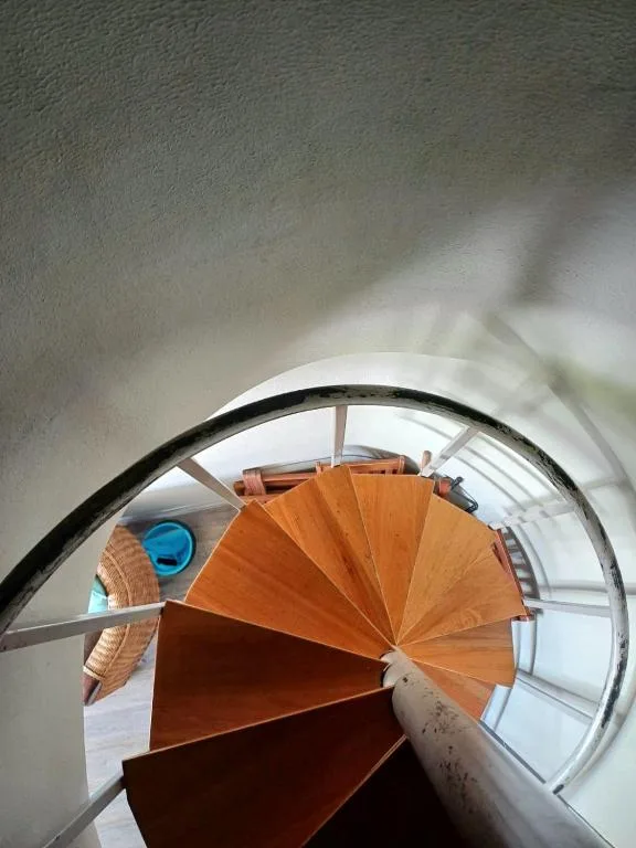 Overhead view of wooden spiral staircase with metal railings