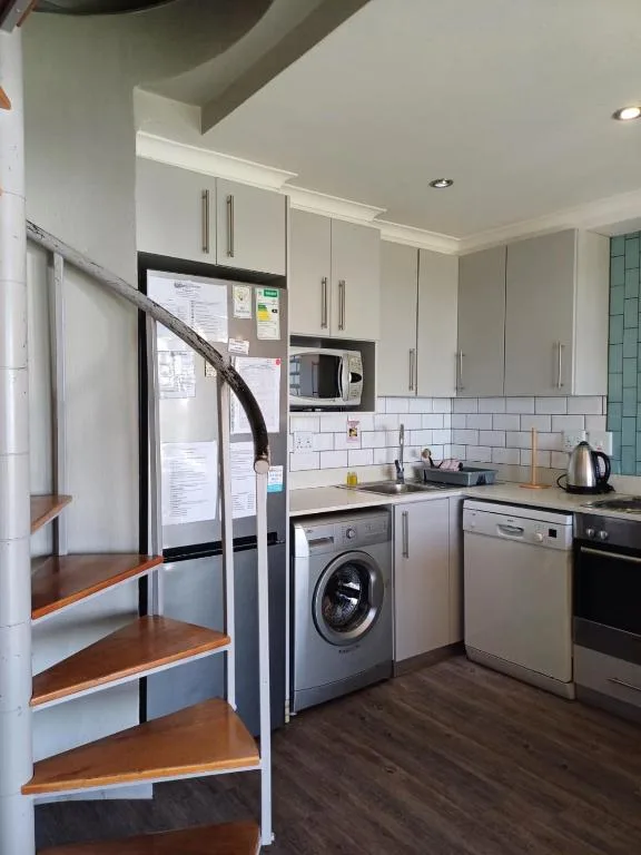 Modern kitchen with white cabinetry, stainless steel appliances, and white subway tile backsplash