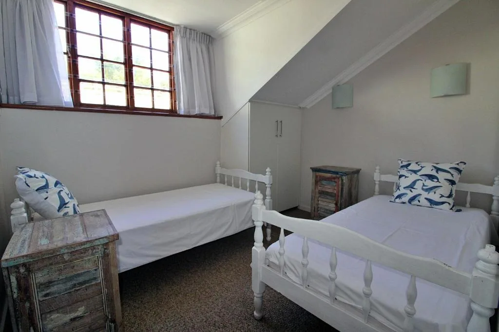 Twin bedroom with white iron beds and blue patterned pillows