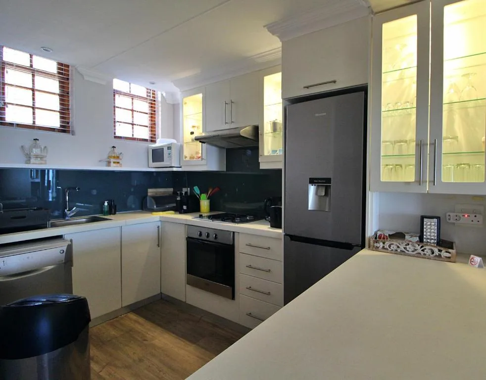 Modern kitchen with white cabinetry, black appliances, and breakfast counter