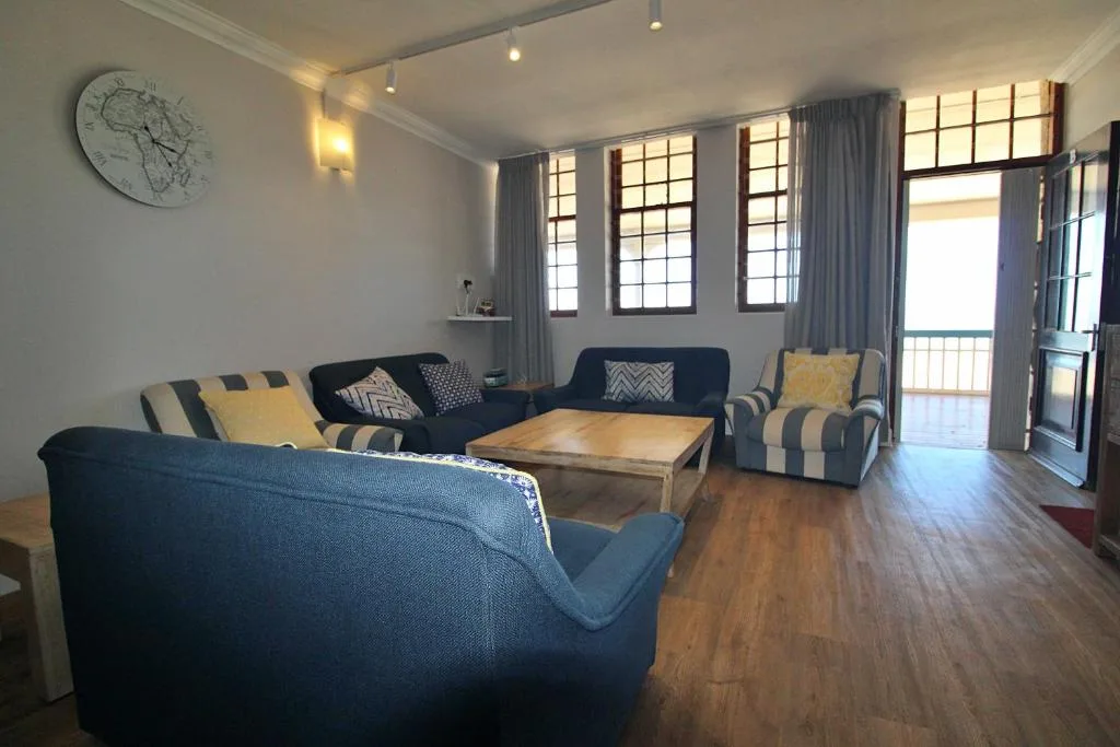 Spacious living room with navy sofas, wooden coffee table, and large windows