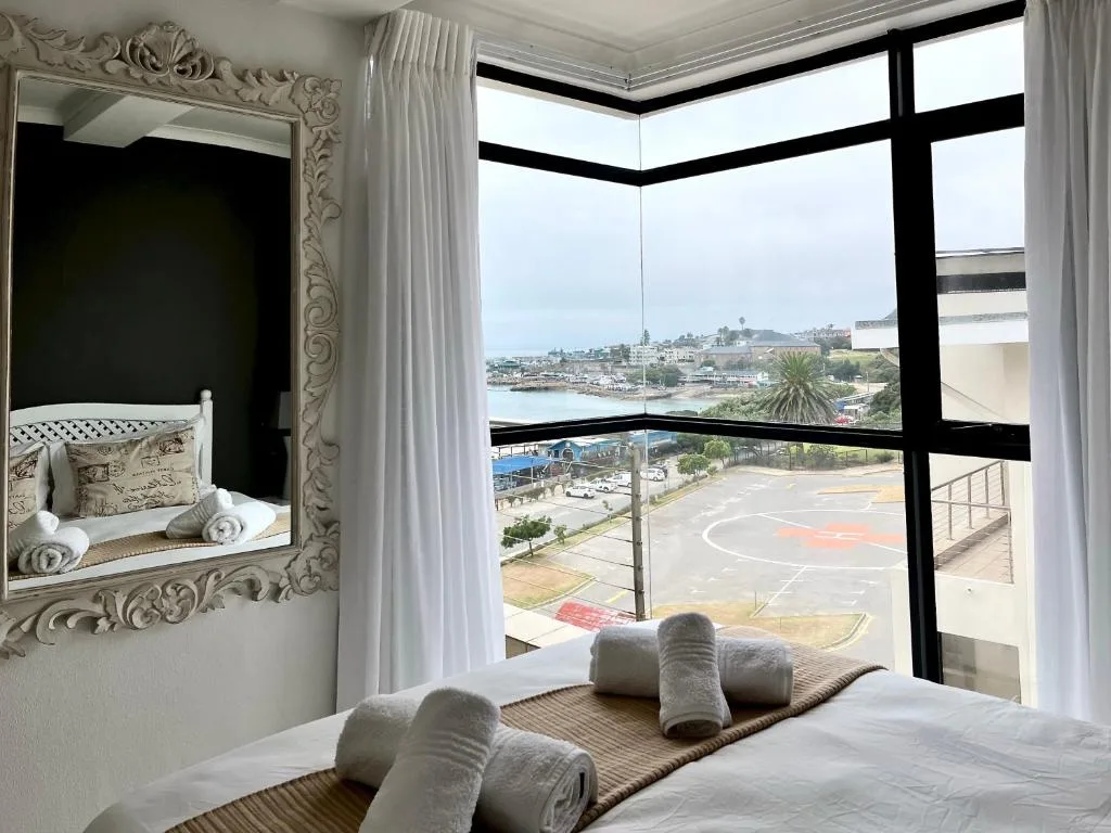 Bedroom with lagoon and harbor views through large windows from balcony