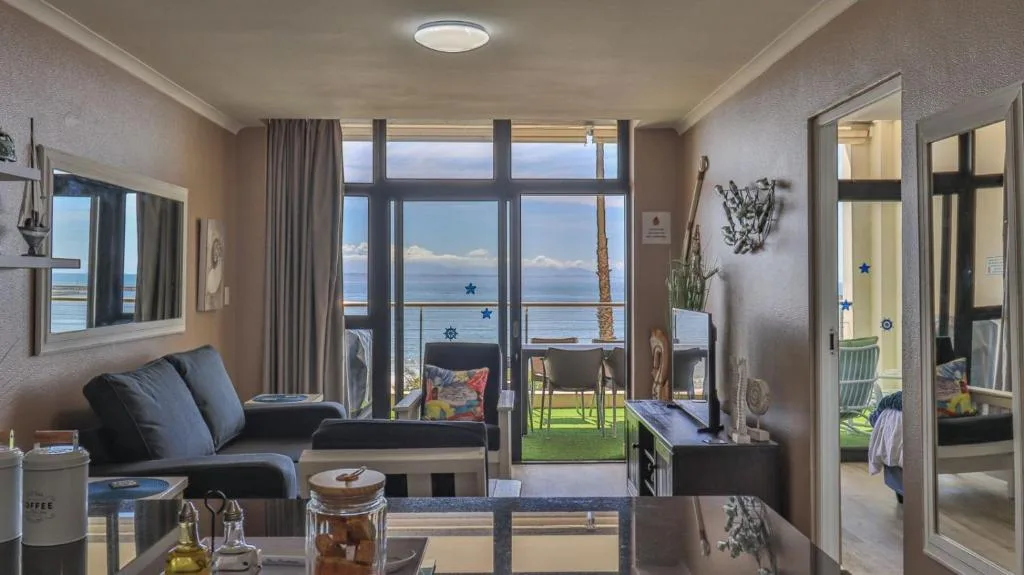 Modern lounge with blue sofa, ocean view through large windows and sliding doors