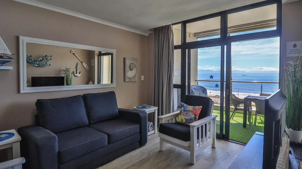 Modern lounge with dark sofa and ocean view through large windows