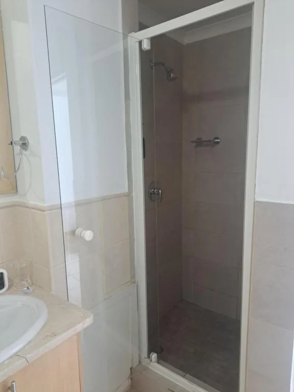 Modern bathroom with glass shower enclosure and pedestal sink