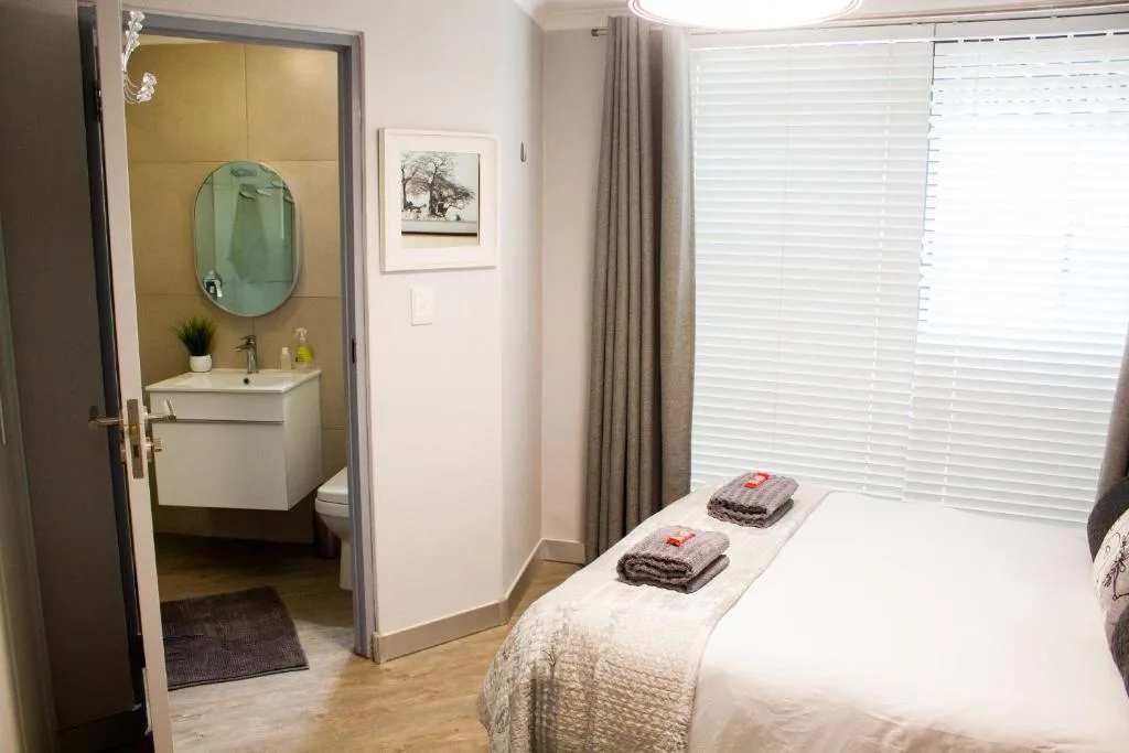 Bright bedroom with en-suite bathroom, double bed, and modern furnishings