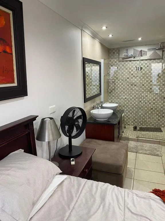 Modern ensuite bathroom with tiled shower enclosure and dual vanity sinks