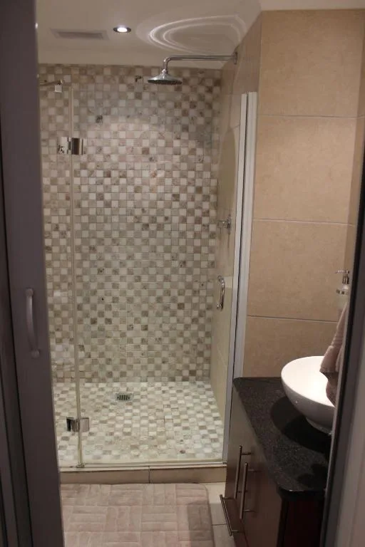 Modern bathroom with glass-enclosed shower and mosaic tiling