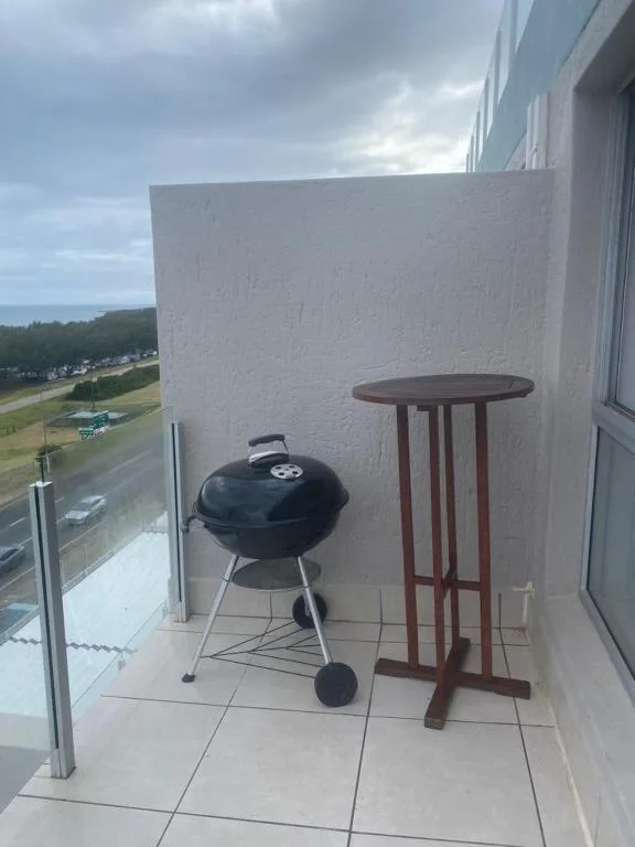 Outdoor balcony with braai grill and side table overlooking coastal town