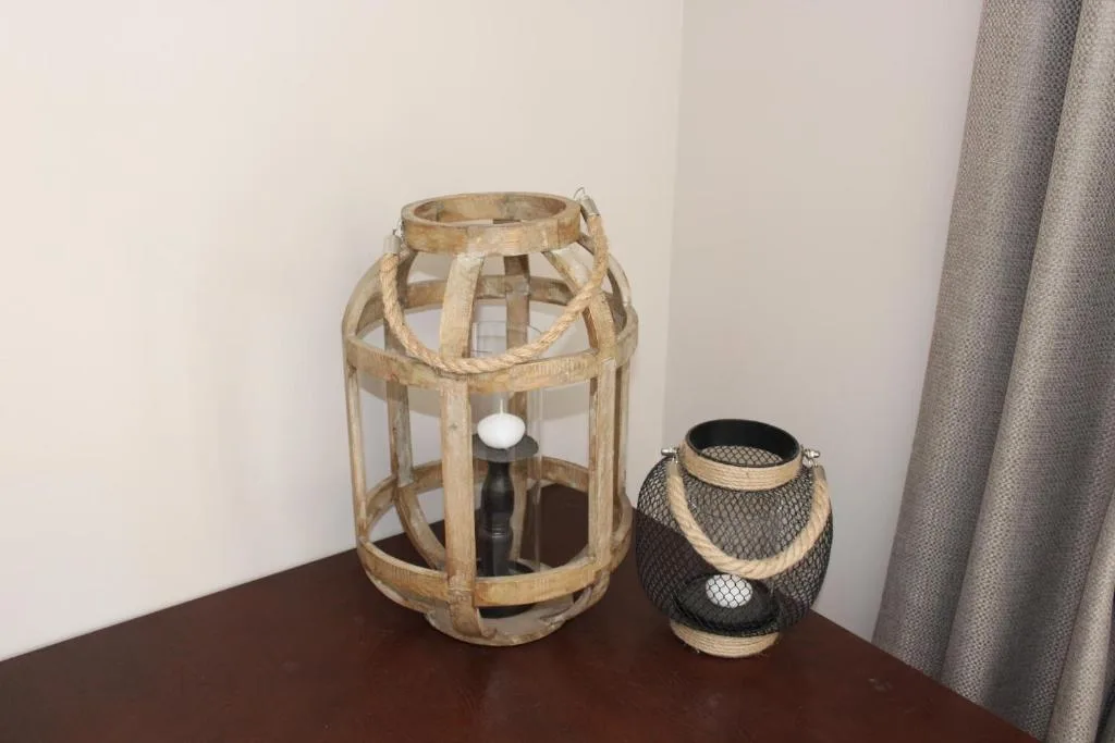 Decorative wooden lanterns with rope handles on bedroom nightstand