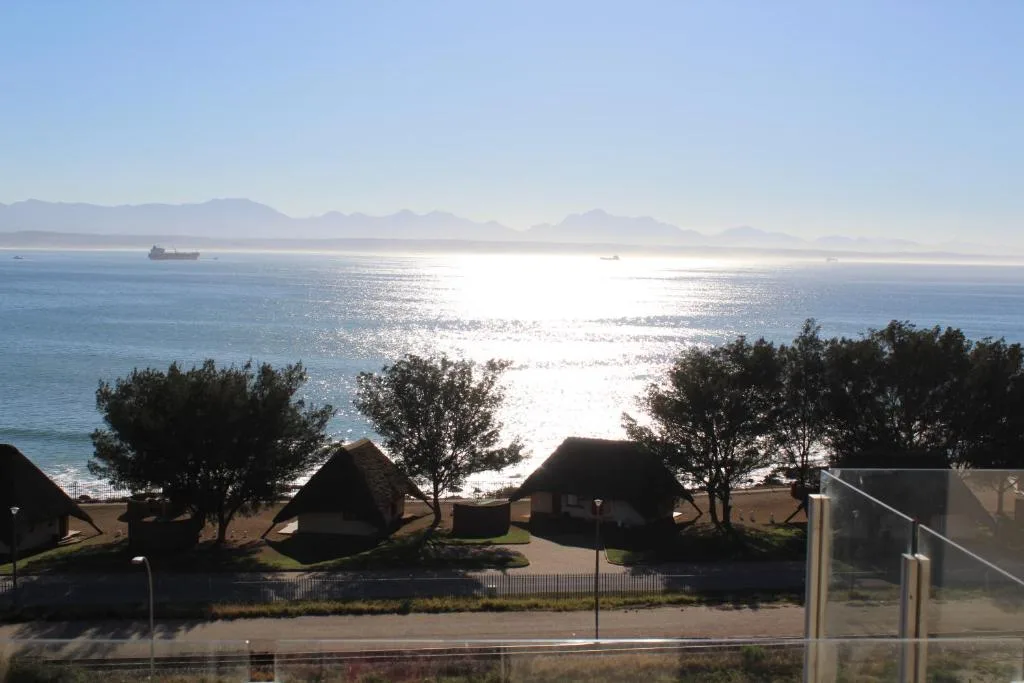 Sparkling ocean view with distant mountains and coastal shipping vessels
