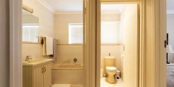 Bright bathroom with vanity, shower enclosure, and toilet fixtures