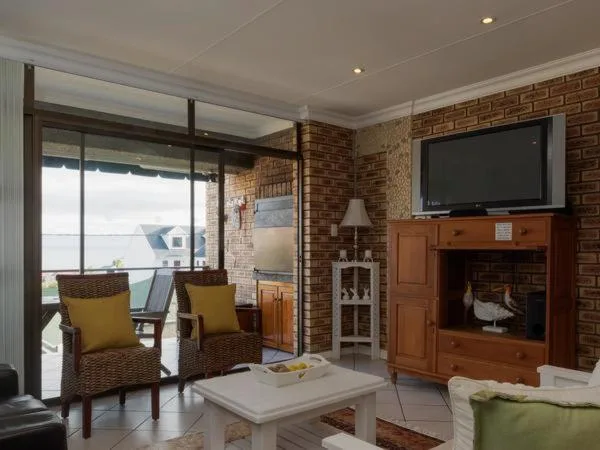 Spacious lounge with fireplace, ocean views through glass doors, comfortable seating
