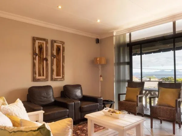 Spacious lounge with leather armchairs, large windows overlooking ocean views