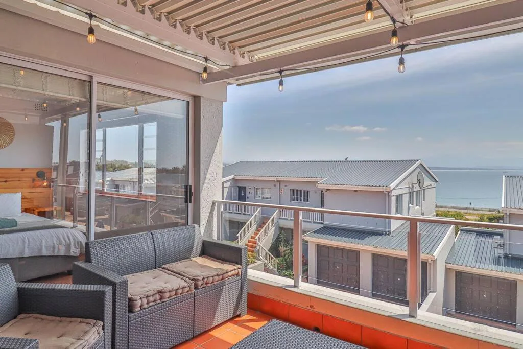 Covered outdoor seating area with lagoon views and neighboring properties