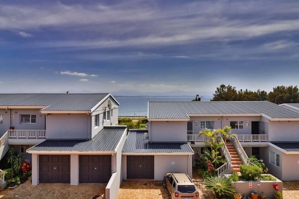 Modern beachfront residential complex with metal roofs overlooking lagoon