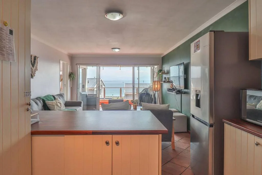 Modern kitchen with island counter overlooking ocean views and deck beyond