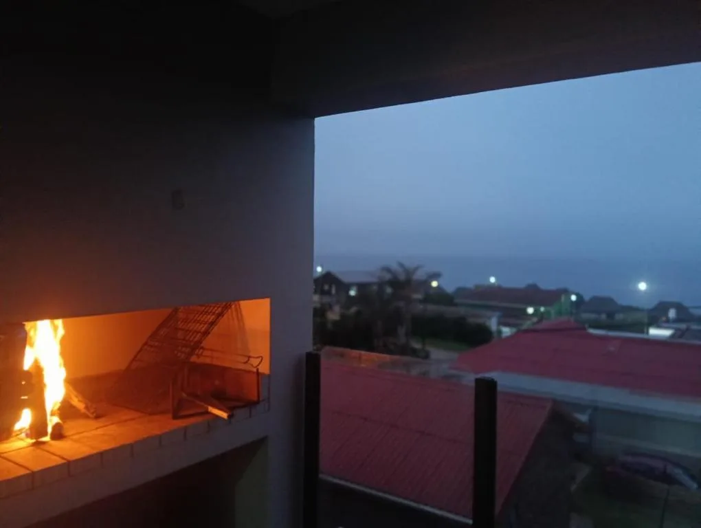 Evening braai area with fireplace overlooking town lights at dusk