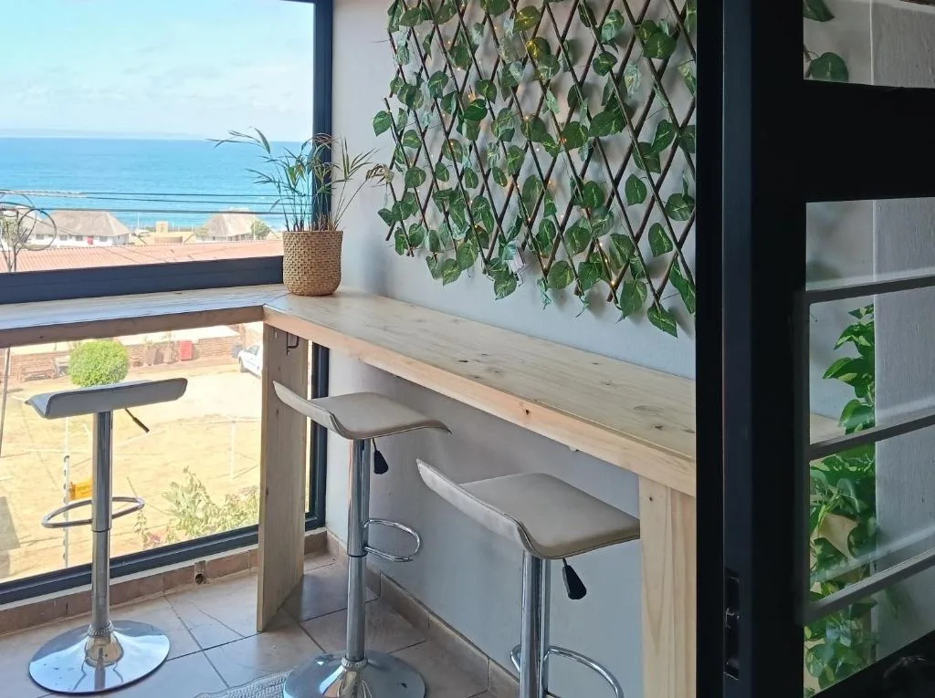 Coastal balcony with bar seating overlooking ocean and beach town
