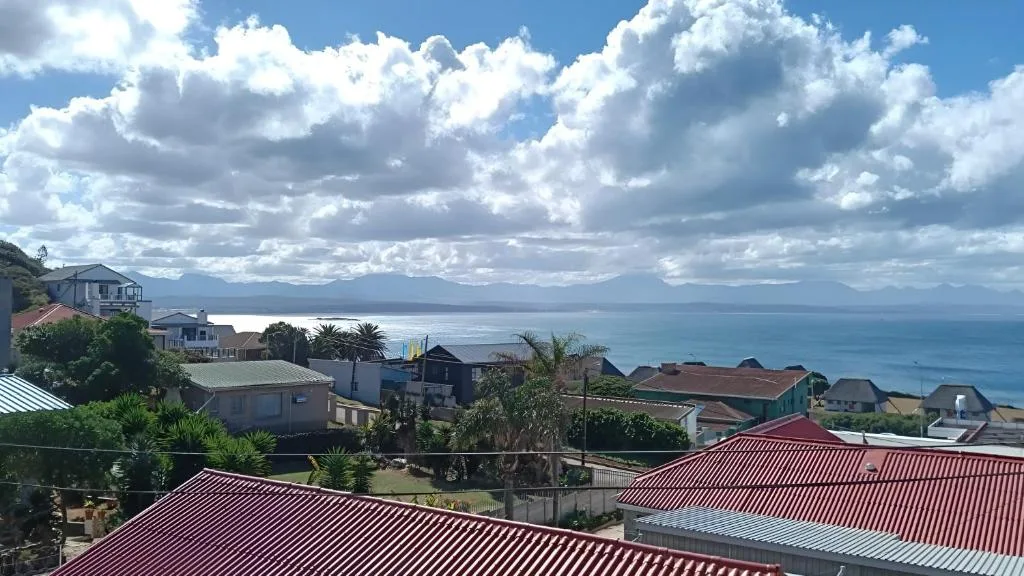 Panoramic coastal view of Mossel Bay with ocean, mountains, and residential properties