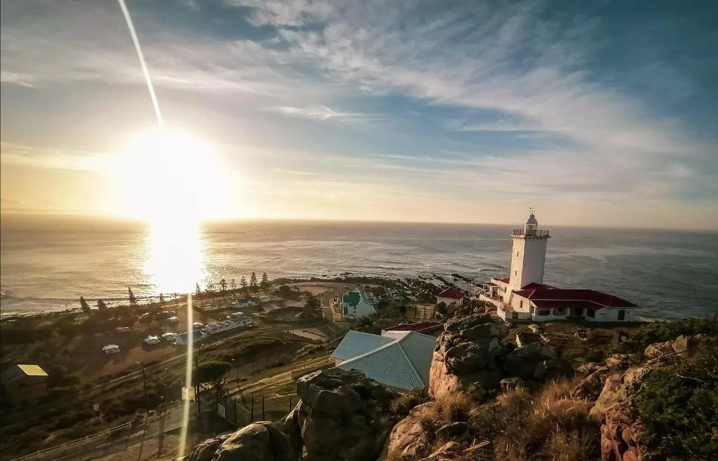 Panoramic sunset ocean view with lighthouse and coastal landscape