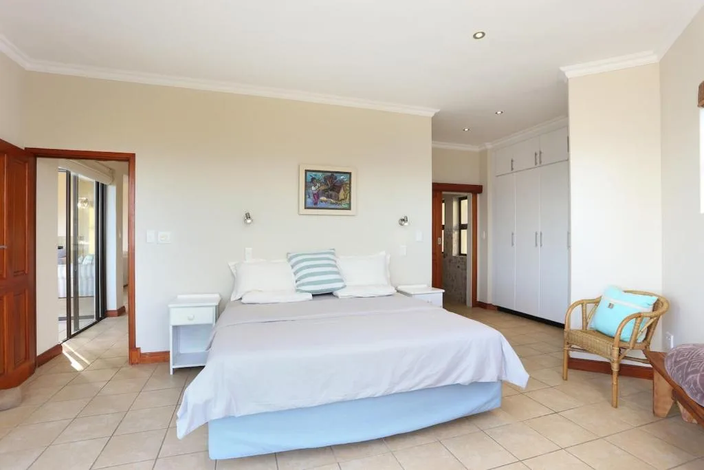 Spacious bedroom with queen bed, white bedding, and built-in wardrobes